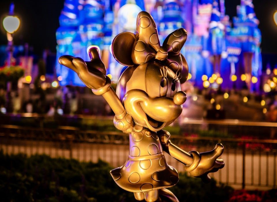 A statue if Mini Mouse in front of castle